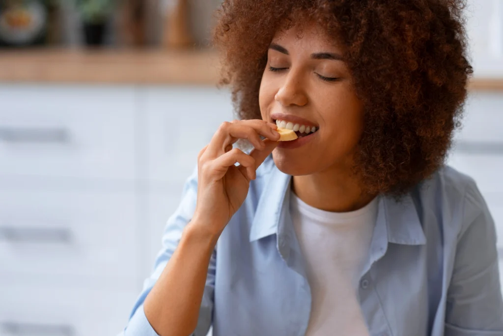 Mulher comendo biscoito e ilustrando as características sensoriais dos alimentos